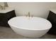 Close up on luxurious soaking tub with modern gold hardware at 8620 Dukes Lake Rd, Zebulon, NC 27597