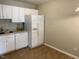 Practical kitchen featuring white cabinets and modern appliances adjacent to a functional eating area at 8650 Neuse Landing Ln # 101, Raleigh, NC 27616