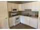 Functional kitchen featuring white cabinets, modern appliances, and ample countertop space at 8650 Neuse Landing Ln # 101, Raleigh, NC 27616