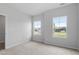 Bright bedroom featuring neutral carpet and walls, two windows, and a standard closet at 89 Grove Township Way, Angier, NC 27501