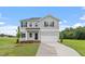 Charming two-story home with gray siding, an attached garage, and a well-manicured lawn at 89 Grove Township Way, Angier, NC 27501