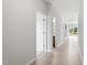 Bright hallway featuring wood-look flooring, white walls, and doors leading to other rooms at 89 Grove Township Way, Angier, NC 27501