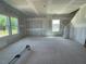 Spacious, unfinished living room area with two large windows and a staircase at 89 Grove Township Way, Angier, NC 27501