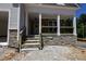 Inviting covered front porch with stone accents, wooden railing, and classic columns at 90 Purslane Dr, Franklinton, NC 27525