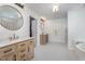 Well-lit bathroom featuring double vanities, modern fixtures, and a glass-enclosed shower at 106 Teak Cir, Garner, NC 27529