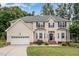Charming two-story home with neutral siding, a well-manicured lawn and an attached two-car garage at 106 Teak Cir, Garner, NC 27529