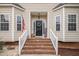 Inviting front entrance with brick steps, white railings, and a decorative wreath on a black front door at 106 Teak Cir, Garner, NC 27529