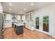 Spacious gourmet kitchen with white cabinetry, quartz countertops, a large island, and stainless steel appliances at 106 Teak Cir, Garner, NC 27529