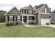 Charming two-story home featuring a welcoming front porch, attached garage, and lush green lawn at 1108 Agio Ct, Zebulon, NC 27597
