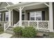 Close up of a cozy front porch with white railings and a meticulously maintained garden at 1108 Agio Ct, Zebulon, NC 27597