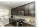 Well-lit kitchen with dark cabinetry, stainless steel appliances, and granite countertops at 1108 Agio Ct, Zebulon, NC 27597