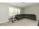 Spacious living room with large corner couch, carpet, and natural light from a window at 1108 Agio Ct, Zebulon, NC 27597
