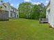 Expansive backyard featuring a manicured lawn and mature trees, with a deck on the side of the home at 113 Laurel Branch Dr, Cary, NC 27513