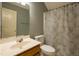 Neutral bathroom featuring a oak vanity, toilet and shower with patterned shower curtain at 113 Laurel Branch Dr, Cary, NC 27513