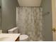Bathroom featuring a oak vanity, toilet and shower with patterned shower curtain at 113 Laurel Branch Dr, Cary, NC 27513