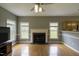Cozy living room with hardwood floors, a fireplace, and large windows offering natural light at 113 Laurel Branch Dr, Cary, NC 27513