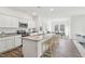 Modern kitchen featuring white cabinets, an island with seating, and an adjacent dining area at 115 Gladstone Loop, Clayton, NC 27520