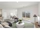 Staged open-concept living room with sliding glass doors and view to the dining room at 115 Gladstone Loop, Clayton, NC 27520