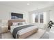 Staged bedroom showcases modern décor, soft lighting, and large windows at 115 Gladstone Loop, Clayton, NC 27520