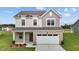 Charming two-story home with a brick facade and a pristine two-car garage, complemented by a well-manicured lawn at 129 Gladstone Loop, Clayton, NC 27520