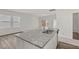 Granite kitchen island with a sink and stainless steel dishwasher, opening to a living room with a view to the back yard at 133 Gladstone Loop, Clayton, NC 27520