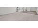 Bright living room featuring neutral carpeting and transitions to wood flooring in the kitchen area at 133 Gladstone Loop, Clayton, NC 27520
