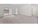 Living room featuring plush carpeting and a sliding glass door leading to the backyard at 133 Gladstone Loop, Clayton, NC 27520