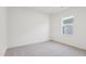 Bedroom with neutral carpet and one window, featuring blank white walls and trim at 137 Gladstone Loop, Clayton, NC 27520