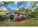 Inviting home exterior showcasing beautiful flowering bushes, well-maintained lawn, and lush green trees at 1518 Echo Rd, Durham, NC 27707