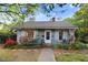 Charming single-story home with a cozy front porch, flowering bushes, and sidewalk leading to the front door at 1518 Echo Rd, Durham, NC 27707