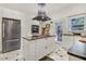 Modern kitchen with white cabinets, center island with gas range, stainless steel refrigerator and stylish floor tiles at 1518 Echo Rd, Durham, NC 27707