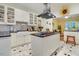 Stylish kitchen featuring an island cooktop, white cabinets, black countertops, and vintage patterned flooring at 1518 Echo Rd, Durham, NC 27707