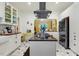 Bright kitchen with island gas range, modern vent hood, and white cabinetry with glass fronts at 1518 Echo Rd, Durham, NC 27707