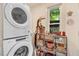 Well-lit laundry room with washer, dryer, and decorative shelving at 1518 Echo Rd, Durham, NC 27707