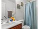 This is a view of the bathroom featuring a vanity, toilet, mirror, and a shower with a light blue shower curtain at 1533 Brown Owl Dr, Raleigh, NC 27610