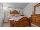 Bedroom featuring wooden furniture, with an end table, a large bed, and a dresser in front of a window at 1533 Brown Owl Dr, Raleigh, NC 27610
