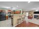 Open kitchen area with wood cabinets, stainless steel appliances, and a bar counter with stools at 1533 Brown Owl Dr, Raleigh, NC 27610