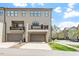 Contemporary townhome showcases an attached two-car garage and a cozy, elevated balcony overlooking a street with sidewalks at 1601 Bowery Dr, Raleigh, NC 27607
