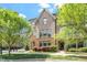 Inviting brick townhouse featuring manicured landscaping, stone accents, and mature trees at 1601 Bowery Dr, Raleigh, NC 27607