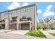Modern townhome featuring a private balcony, two-car garage, and neutral siding, with a view of mature trees and blue sky at 1601 Bowery Dr, Raleigh, NC 27607