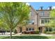 Charming brick townhouse with stone accents, dormer windows, and lush green landscaping at 1601 Bowery Dr, Raleigh, NC 27607