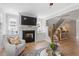 Bright living room with hardwood floors, a fireplace, and staircase with wooden banister at 1601 Bowery Dr, Raleigh, NC 27607