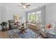 Spacious living room with multiple seating areas, large windows, and a stylish area rug at 1601 Bowery Dr, Raleigh, NC 27607