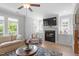 Cozy living room with a fireplace, hardwood floors, and natural light from multiple windows at 1601 Bowery Dr, Raleigh, NC 27607