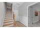 Bright hallway with hardwood floors, wooden stairs, and white wainscoting for a classic look at 1601 Bowery Dr, Raleigh, NC 27607
