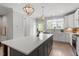 Modern kitchen featuring an island with seating, stainless steel appliances, and updated lighting at 1601 Bowery Dr, Raleigh, NC 27607