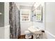 Bright bathroom featuring a pedestal sink, decorative mirror, and window, offering a charming space at 1617 Woodland Ave, Burlington, NC 27215