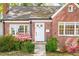 Classic brick home with blooming azaleas, white trim, and a welcoming front entrance with steps at 1617 Woodland Ave, Burlington, NC 27215