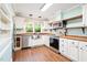 Modern kitchen with white cabinetry, stainless steel appliances, wood countertops, and natural light at 1617 Woodland Ave, Burlington, NC 27215