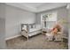 Cozy Bedroom with a plush teddy bear, rocking chair and a bright window at 171 School Side Dr, Spring Lake, NC 28390